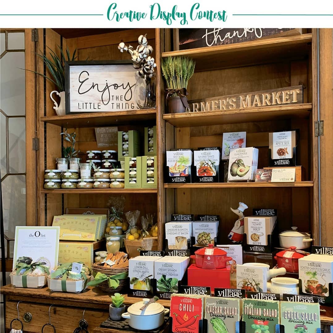 Meet @avillagegiftshop, a finalist in our 2019 Creative Display Contest • “This antique piece houses the gourmet section of our shop! Our building was built in 1867 so we feel this display helps preserve a piece of history. The piece itself is so versatile with shelving, drawers and storage. Our dips, pestos and other delicious goodies look so inviting!” – Diane Agricola • Cast your vote using link in bio.