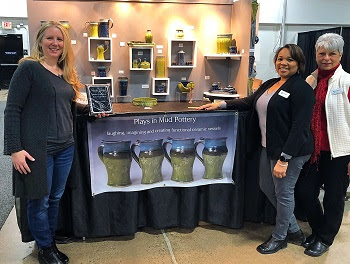 Pictured left to right:  Kelsey Schissell, owner of Plays in Mud Pottery, was awarded the “Best Made in America” product at the Philadelphia Gift Show. Sonya Lowe and Jeannie Dorchak with Urban Expositions presented the award on show site.